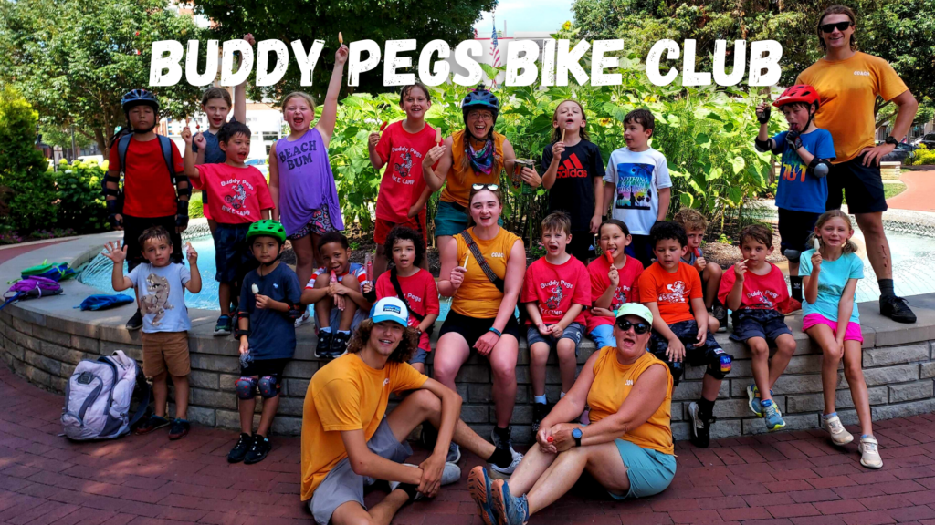 Kids bike coaches and kids on bicycles celebrating at a Buddy Pegs bike club