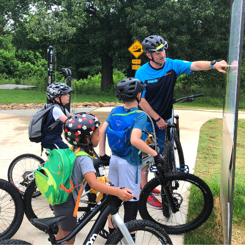 Coach teaching children to ride mountain bikes